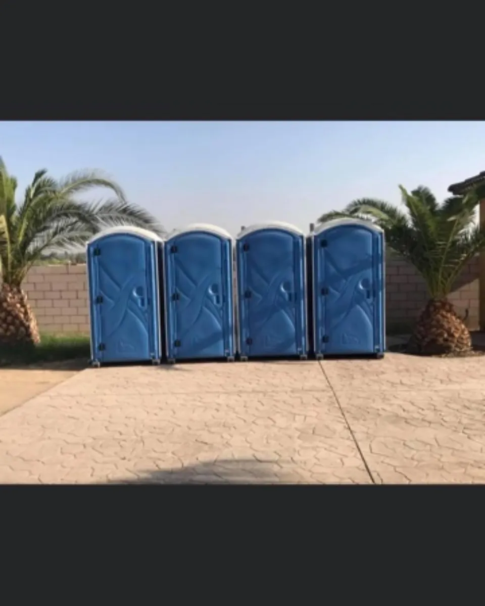 Row of blue portable toilets in an outdoor setting