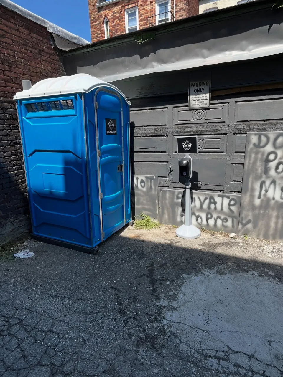 Blue portable toilet beside a building project